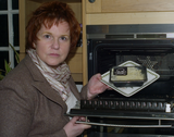Sharon with a ready meal with a skull and crossbones on it to represent how high in saturated fat the meal is