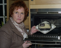 Sharon with a ready meal with a skull and crossbones on it to represent how high in saturated fat the meal is